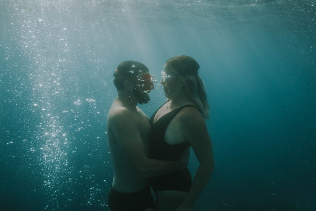 couple hugging each other under water