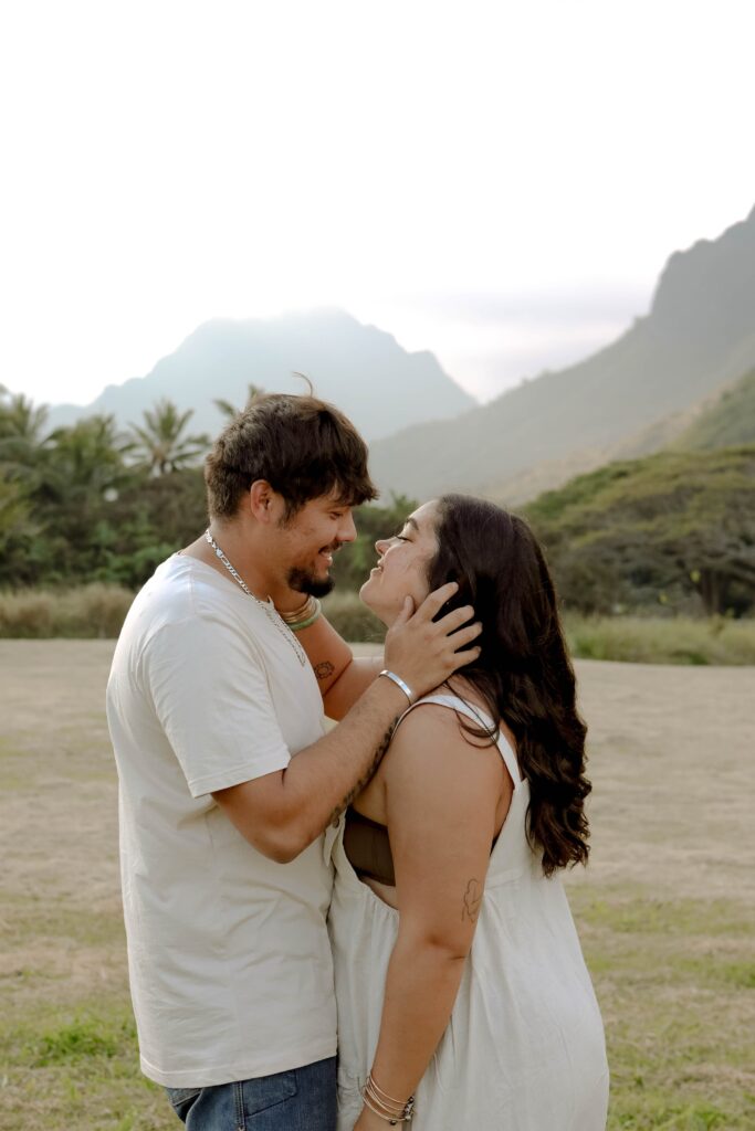 couple embracing each other in front of mountains engagement photos kauai