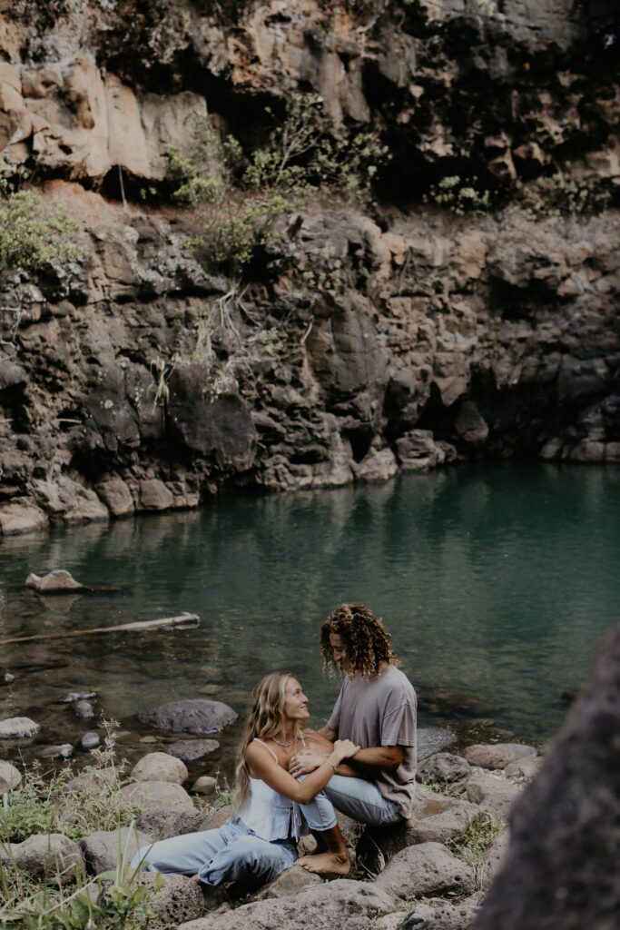 couple sitting on rocks in front of lagoon hawaii adventure elopement