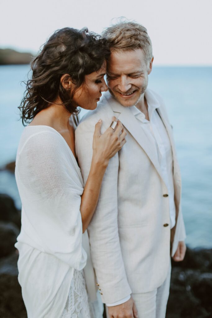 couple hugging in front of ocean Hawaii elopement photographer