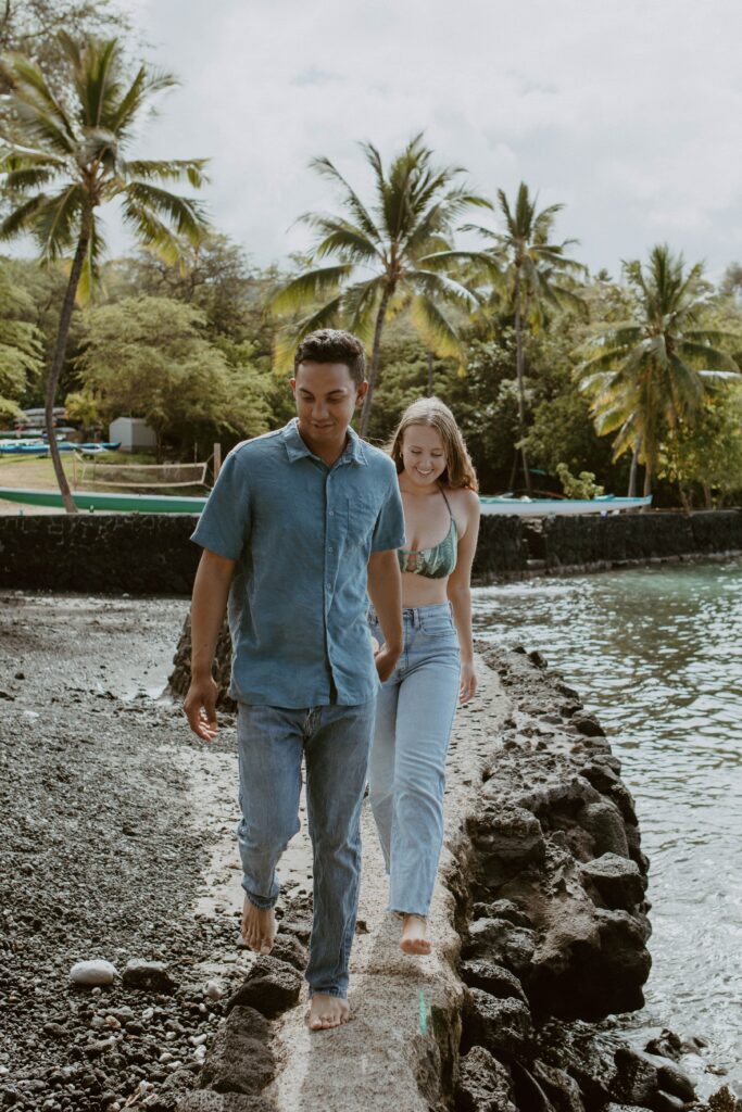 couple walking on cliff next to ocean elopement photographer 