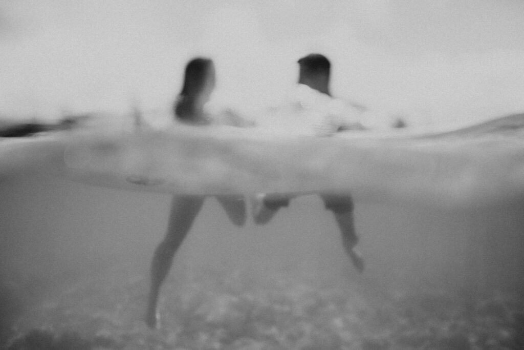 black and white photo of couple in ocean with heads above water hawaii photographers big island 