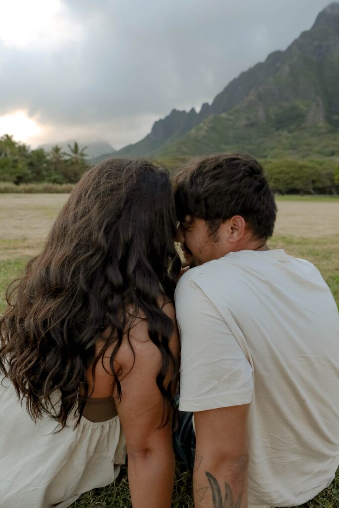 couple leaning foreheads together in front of mountains on oahu engagement photos waikiki