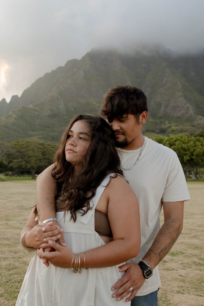 couple holding each other in front of mountains hawaii elopement