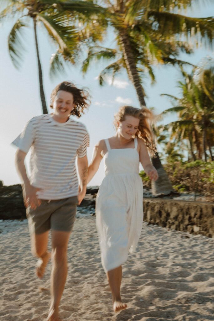 couple running on beach hawaii adventure wedding photographer