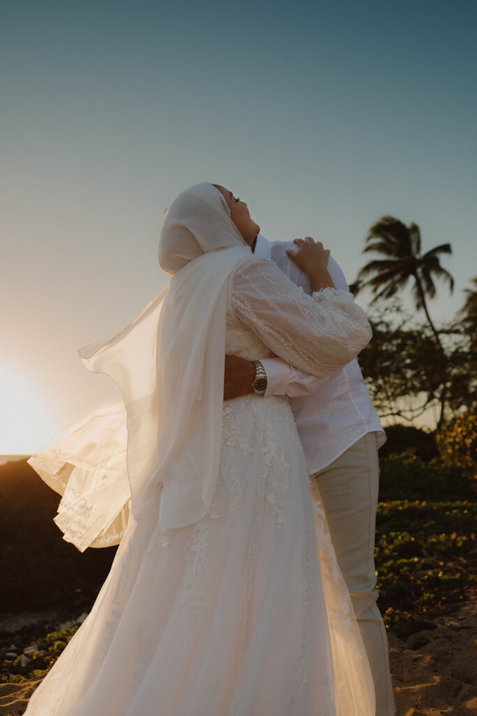 bride and groom hugging on beach