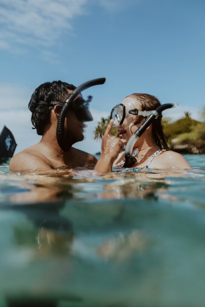 couple in ocean with snorkel masks on Hawaii adventure elopement photographer