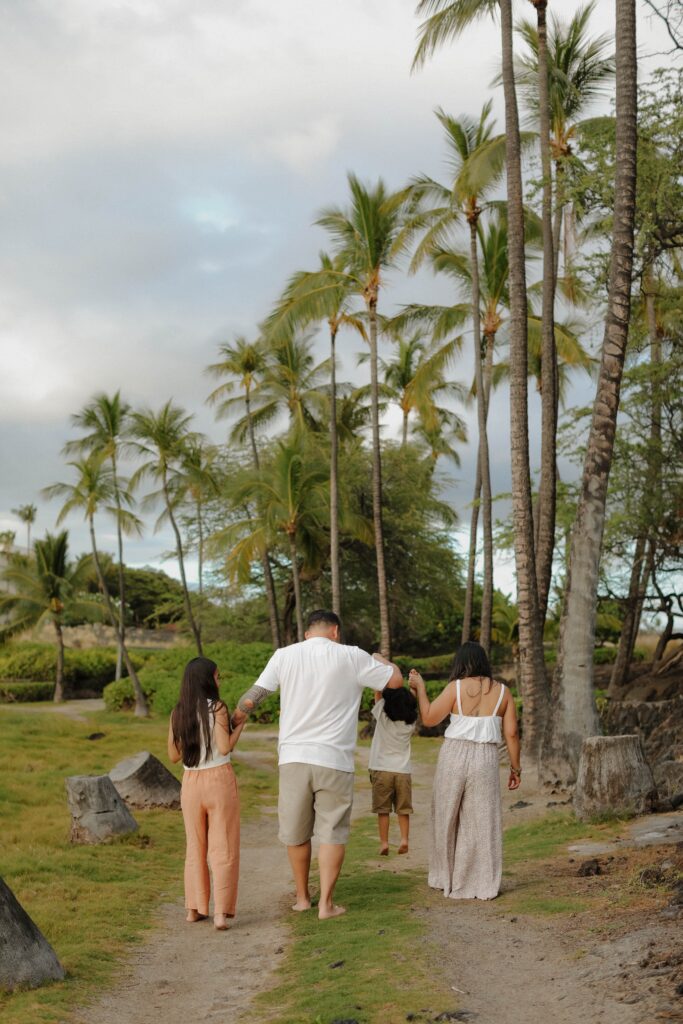 Family walking under palm trees in Hawaii