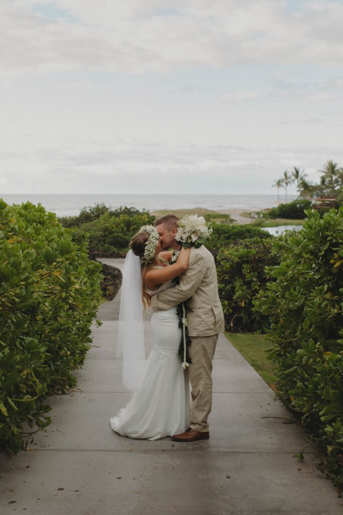 A couple kissing right after saying their vows on the beach in hawaii
